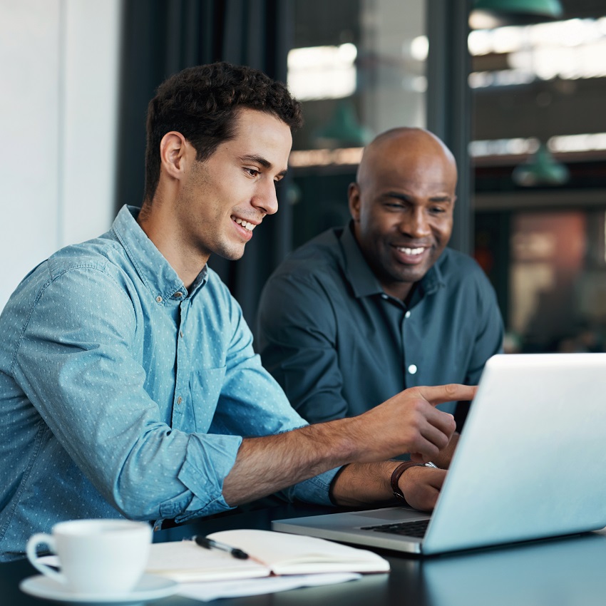 Teamwork, diversity and sales manager planning branding ideas with a creative designer on a laptop in an office. Logo, collaboration and businessman talking to an employee about a development project