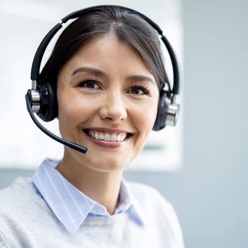 Portrait of a Latin American woman working at a call center in customer service and looking at the camera smiling